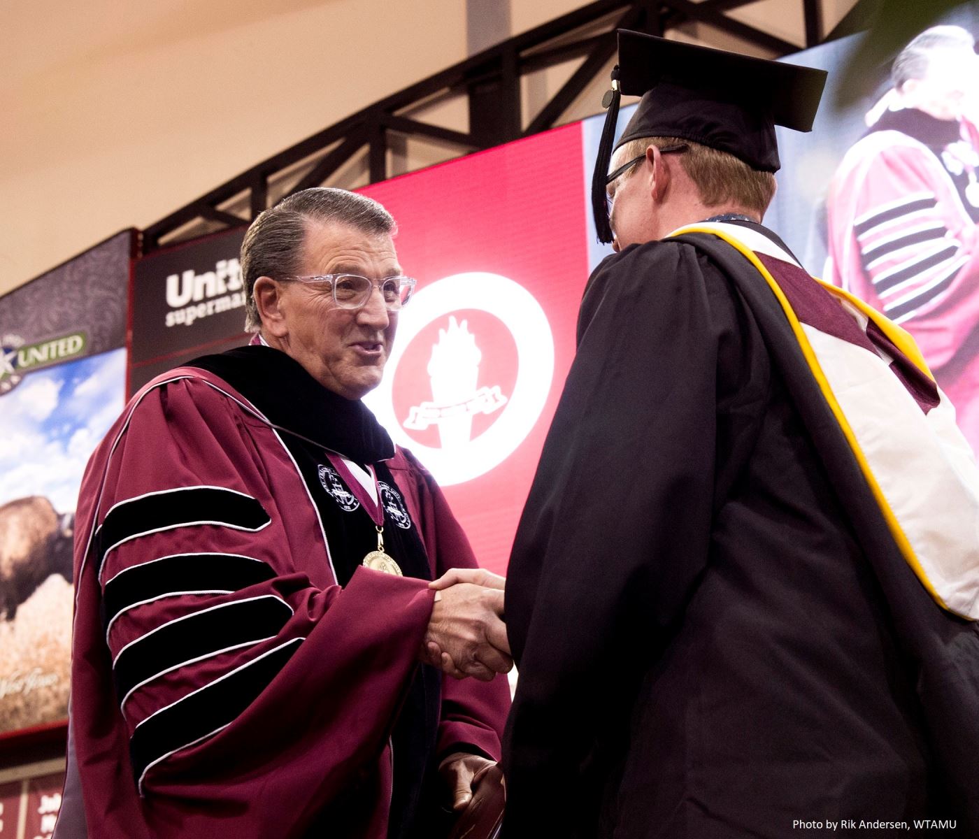 President Wendler shaking hand of graduate at commencement